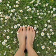 A woman's feet on a daisy covered lawn